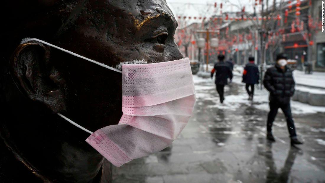 A mask is seen on a statue in Beijing on February 5.