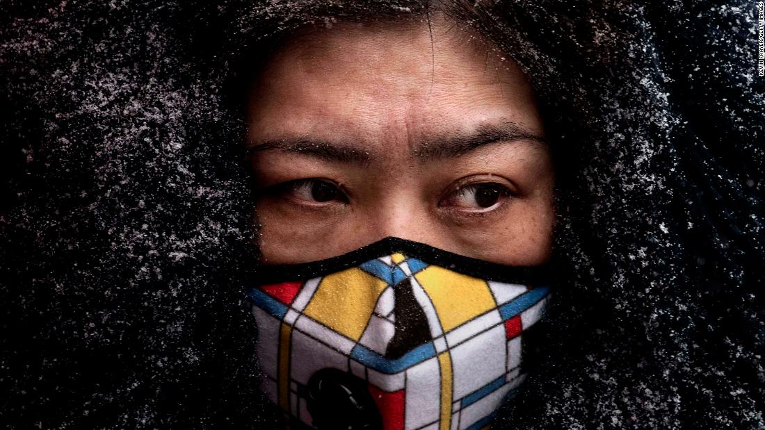 A woman wears a protective mask as she shops in a Beijing market on February 6.