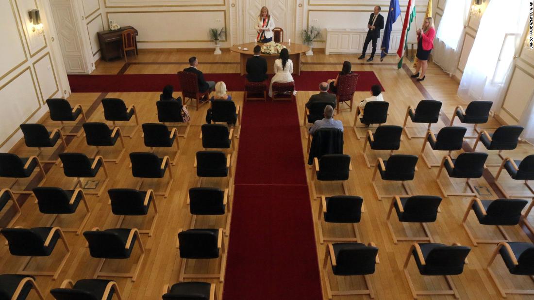 Gyorgy David Jablonovszky and his bride, Timea, are joined by close relatives during their wedding ceremony in Miskolc, Hungary, on March 28. Because of the coronavirus, engaged couples across the globe &lt;a href=&quot;https://www.cnn.com/2020/03/28/us/couples-livestreaming-weddings-wellness-trnd/index.html&quot; target=&quot;_blank&quot;&gt;have had to rethink their walks down the aisle.&lt;/a&gt;