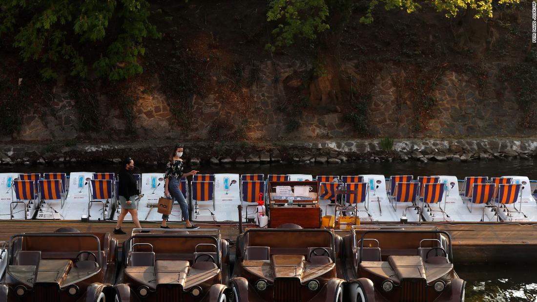 Two women walk to rent a small paddle boat by the Vltava River in Prague, Czech Republic, on April 17.